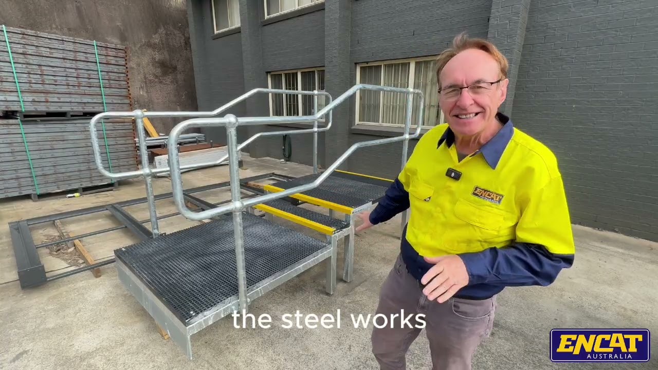 John Ford, ENCAT engineer and director, with a finished hot dip galvanised walkway platform with FRP grating, yellow stair nosings and two-rail handrail